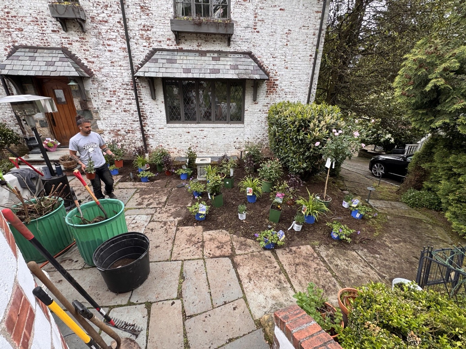 Jay arranging plants in a courtyard garden during an installation